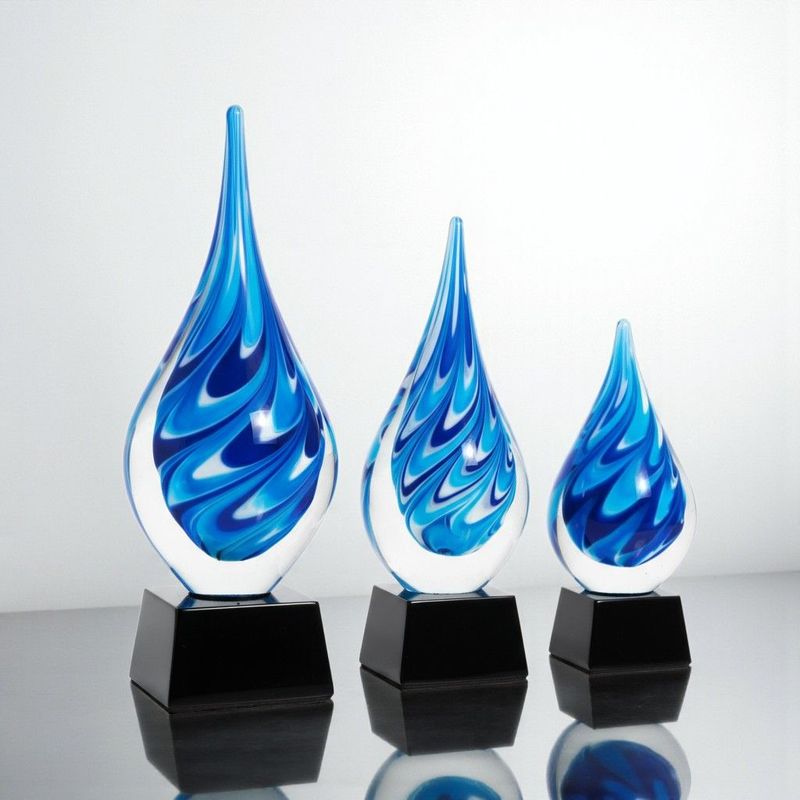 Blaue Glastrophäe in Tropfenform auf schwarzem Glassockel