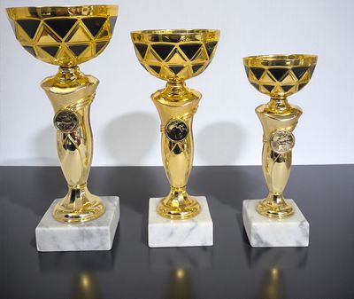 Drei Pokale der Serie ROSE mit schwarz-goldfarbener Schale, goldfarbenem Pokalkörper mit Emblemhalter und Marmorsockel in unt