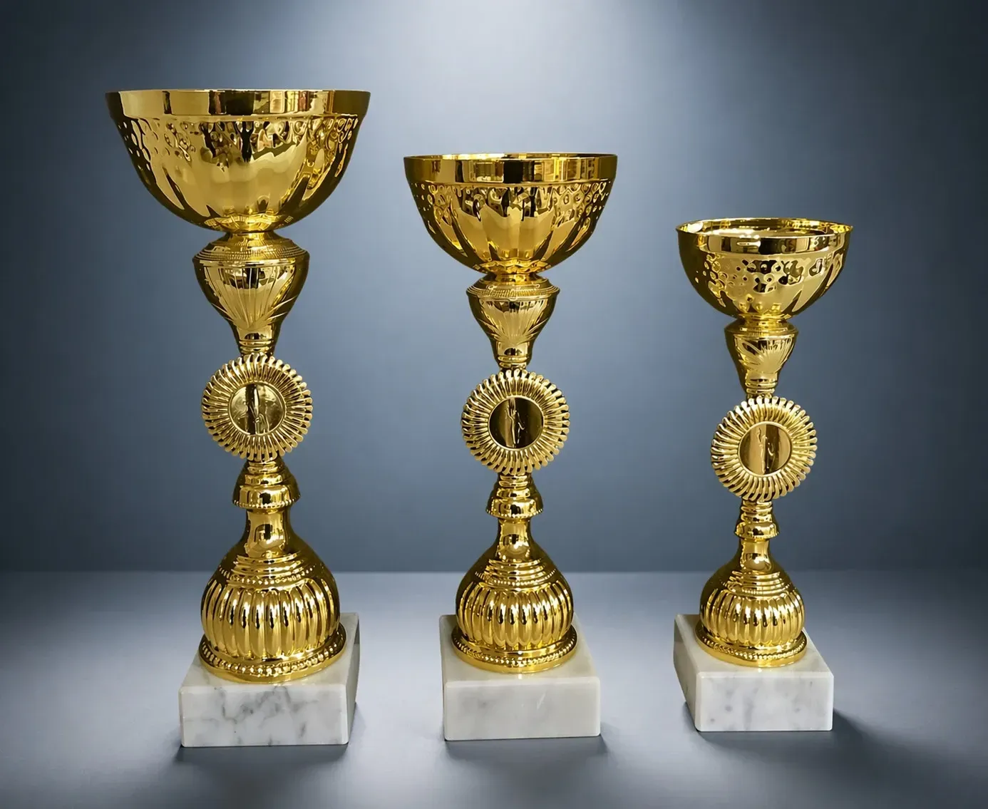 Pokal 3er-Pokalset „Juno“ mit goldfarbenen Pokalen, strukturierter Schale, Marmorsockel und Mittelteil in Gold
