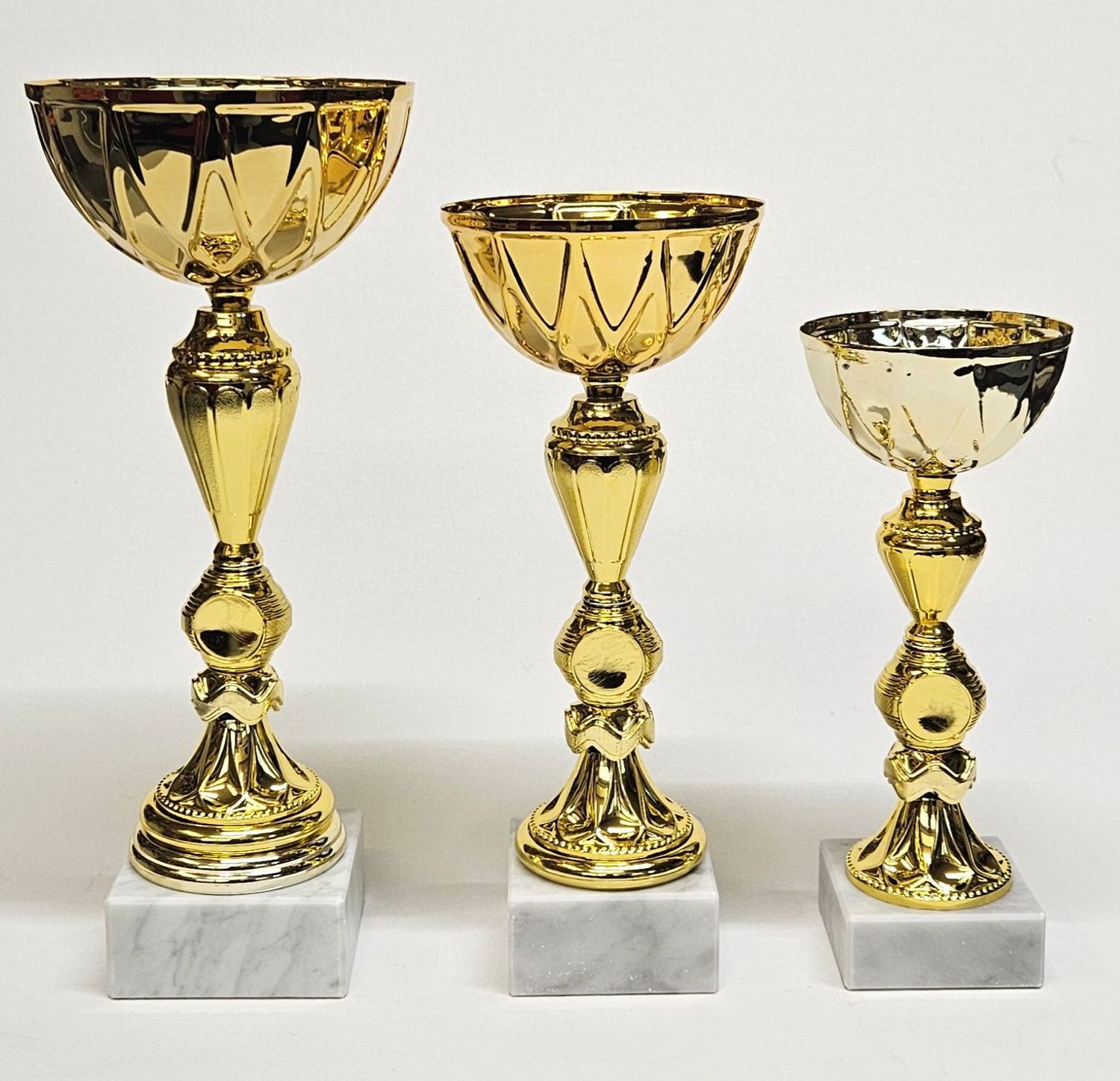 Pokal „Vesta“ im 3er-Set mit goldfarbener Schale in klassischer Form, dekorativem Schaft und weißem Marmorsockel in drei unte