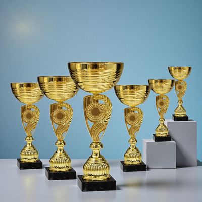 Pokal-Set ULLA mit sechs goldfarbenen Pokalen in abgestuften Höhen auf schwarzen Sockeln, dekorativ…