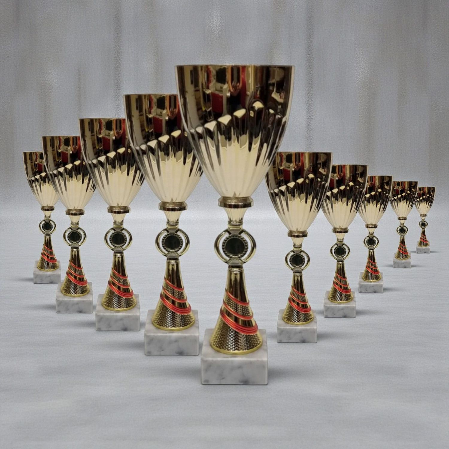 Pokal-Set Eibsee mit Pokalen in Gold-Rot und Silber-Blau, abgestufte Höhen auf hellen Sockeln, neutraler Hintergrund.