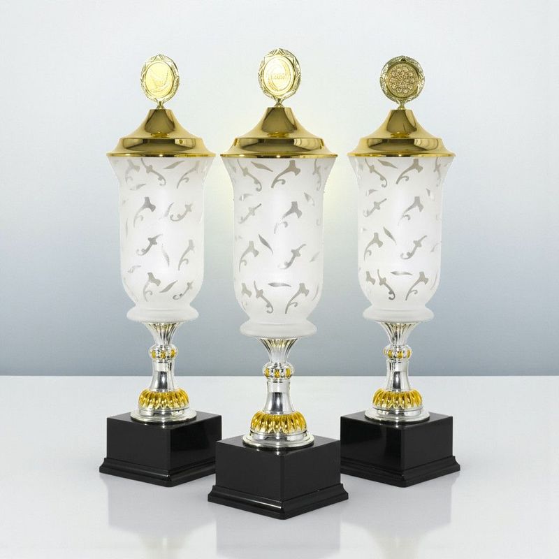 Glaspokal „Achensee“ mit satiniertem Glas, goldfarbenem Deckel und Emblemträger auf schwarzem Marmorsockel.