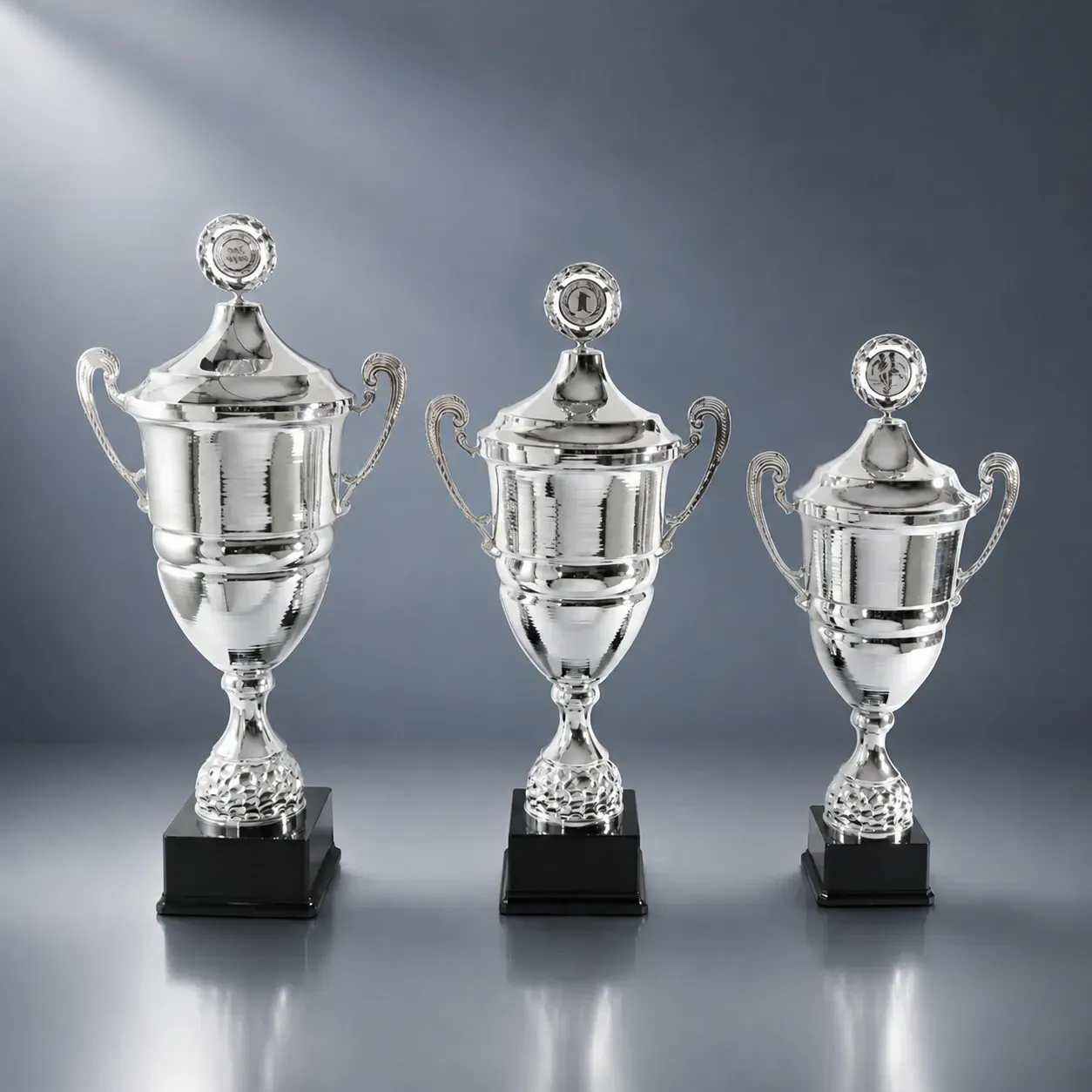 Wanderpokal Wanderpokal-Serie „Champion“ in Silberoptik mit Deckel und Kranz, drei Größen auf schwarzem Kunststoffsockel
