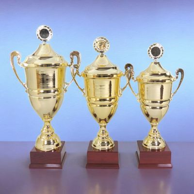 Wanderpokal-Serie „Europa“ in Goldoptik mit Deckel und Kranz, drei Größen auf dunklem Holzsockel