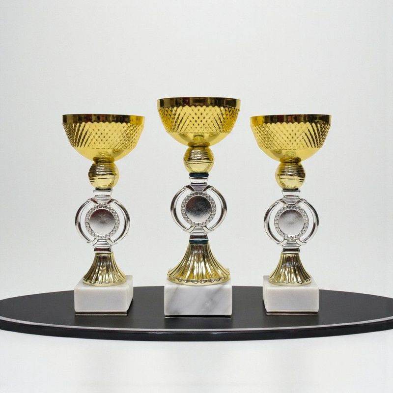 Pokal Free Willy mit strukturierter goldfarbener Schale, rundem Emblemträger, klassischem Mittelteil und weißem Marmorsockel