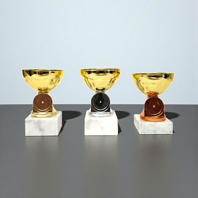 Pokal Lucky mit glatter Schale, farblich unterschiedlichen Mittelstücken, rundem Emblemfeld und weißem Marmorsockel