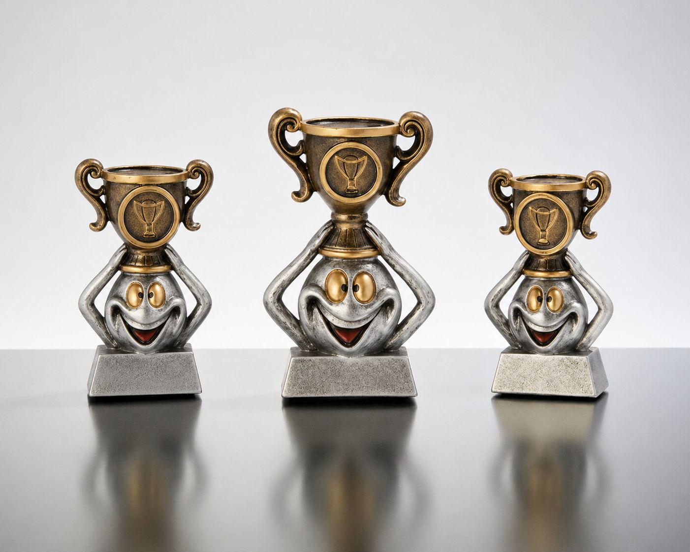 Funny Winners Cup ab € 4,80 Funny Winners-Cup Pokal-Set aus Resin mit Comic-Figur und Pokalaufsatz, 3 Größen auf grauem Sockel