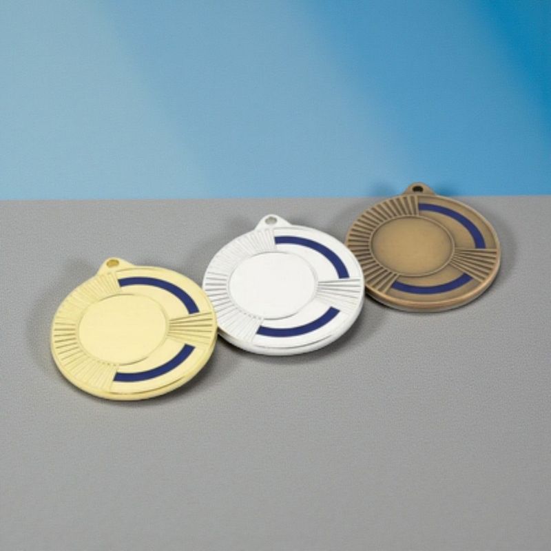 Metallmedaille mit facettiertem Randdesign und farbigem blauen Akzent. Durchmesser Ø 5 cm