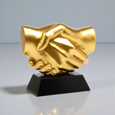 Goldene Resin Trophäe mit Handschlag auf schwarzem Sockel