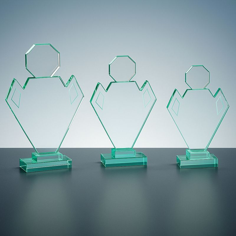 Jadeglas-Trophäe in geometrischer Figurenform aus grünem Glas auf graublauem Hintergrund.