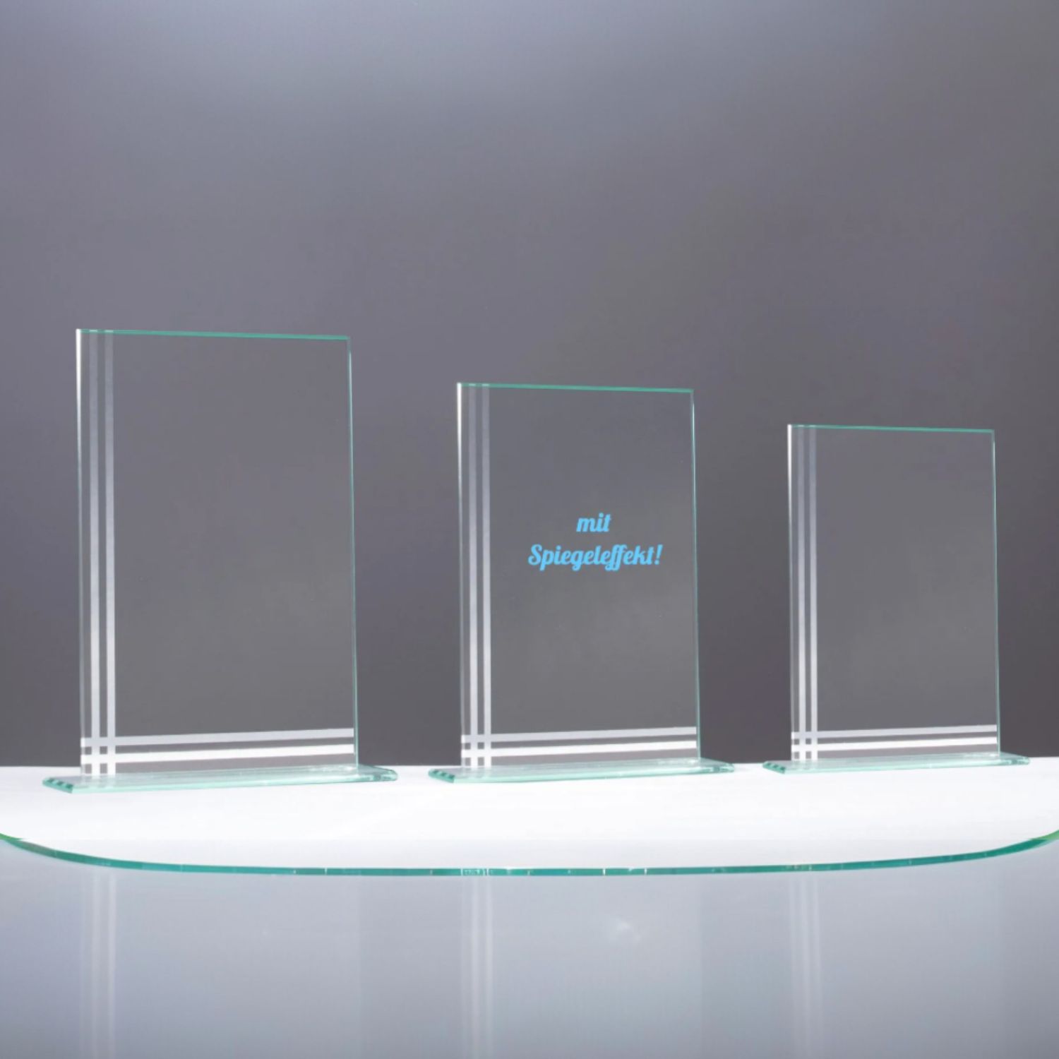 Drei klare Glastrophäen aus 4 mm starkem Glas mit spiegelnden Ornamentkanten in abgestuften Größen