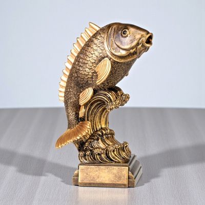 Große Fischtrophäe aus Resin mit Fisch auf Welle in goldfarbener Optik