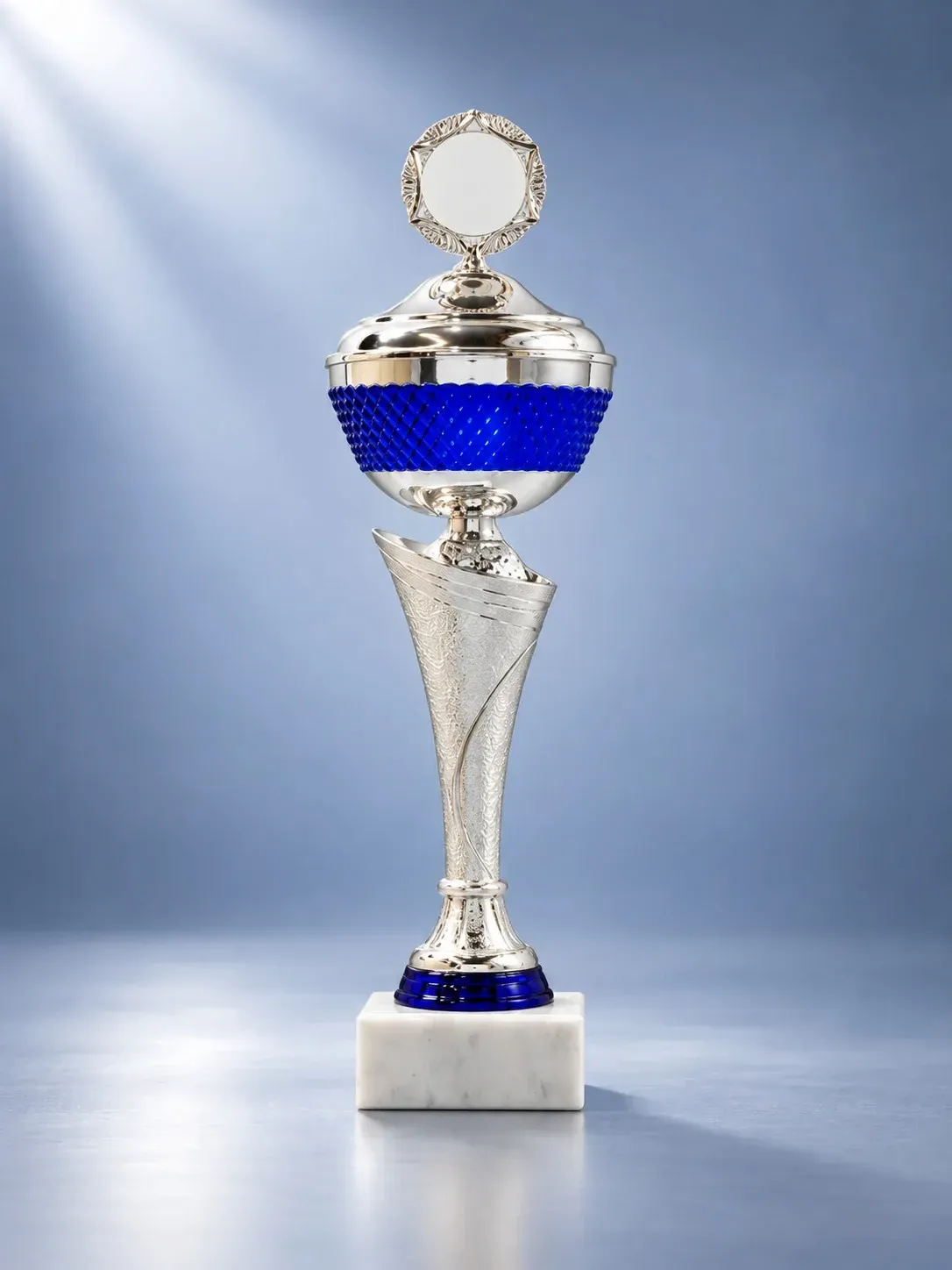 Pokal Azzurro – Silber-blauer Deckelpokal, 10 Größen ab € 16,00 Pokal Azzurro in Silber-Blau mit verziertem Säulenschaft, silbernem Deckel, rundem Emblemträger und weißem Marmorsockel.