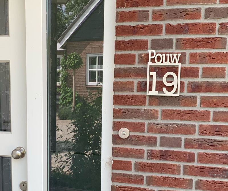 rvs naambord met familienaam en huisnummer op gevel