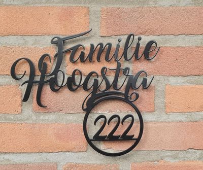 Zwart RVS naambord met familienaam en huisnummer, stijlvol voordeur naambord