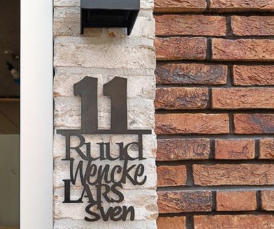 Zwart verticaal naambord met huisnummer en voornamen