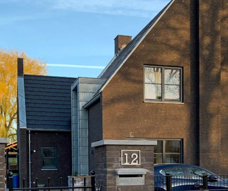 Rechthoekig rvs huisnummerbord voor buiten Rechthoekig rvs huisnummerbord met huisnummer 12 op een gemetselde poer voor een woning