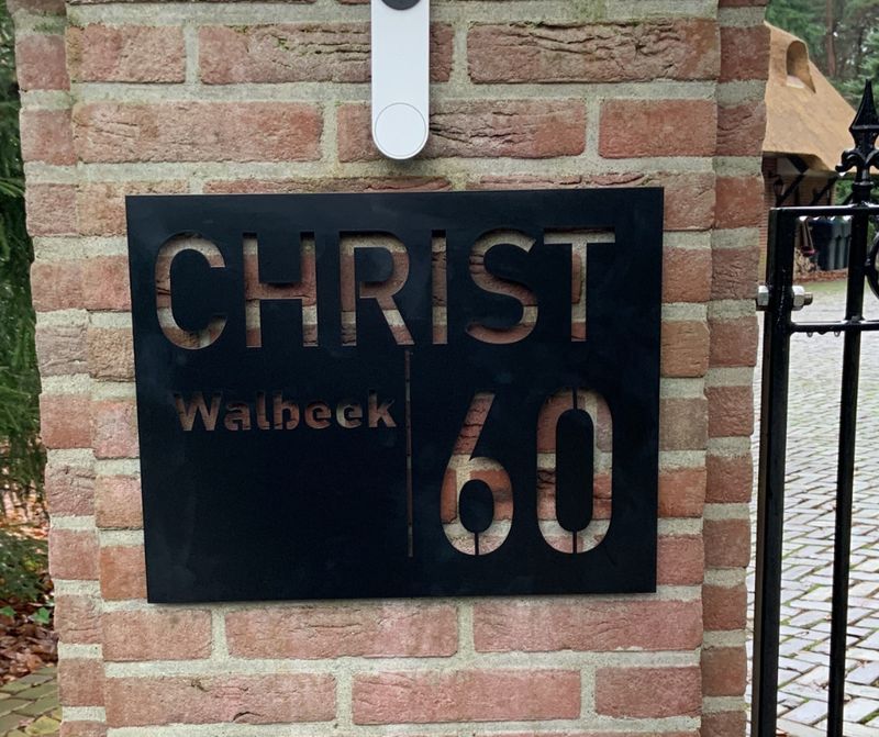 Modern zwart RVS naambord met familienaam en huisnummer, stijlvol naambord voor buiten Naambord voordeur zwart RVS met huisnummer en familienaam gemonteerd naast voordeur