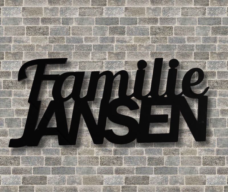 Zwart kunststof naambord met familienaam Zwart kunststof naambord met gepersonaliseerde familienaam voor de voordeur