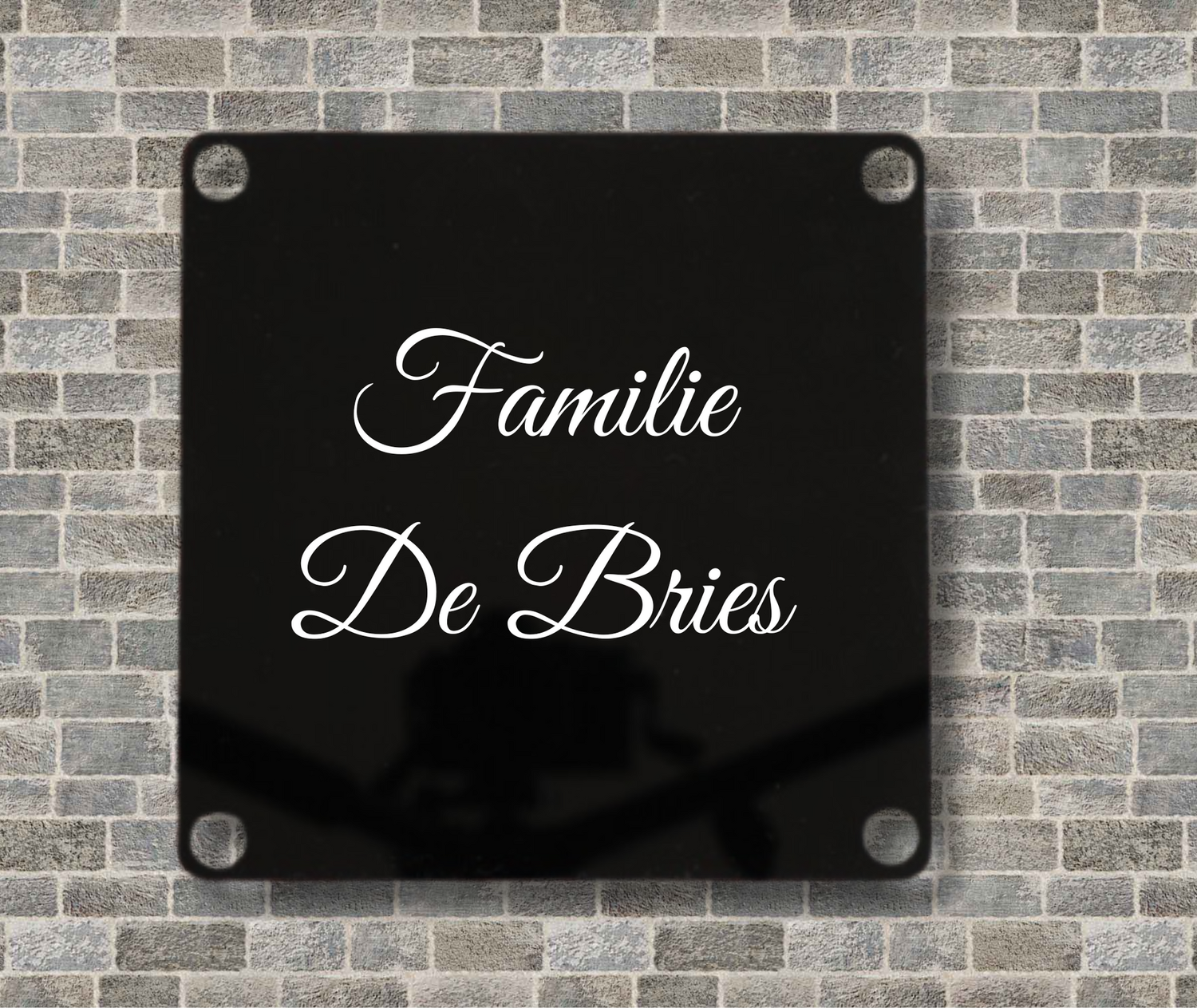 Zwart kunststof naambord met gepersonaliseerde familienaam voor de voordeur