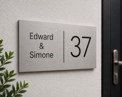 RVS naambord met Edward en Simone onder elkaar en groot huisnummer op lichte muur