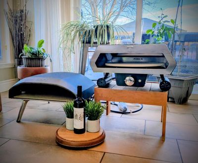 Two outdoor wood and gas pizza ovens displayed on patio