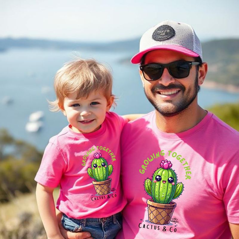 Mini & Me – Growing Together Cactus Set Fuchsia Father and child in matching fuchsia Mini & Me T-shirts with cactus, flower, and 'Growing Together' text.
