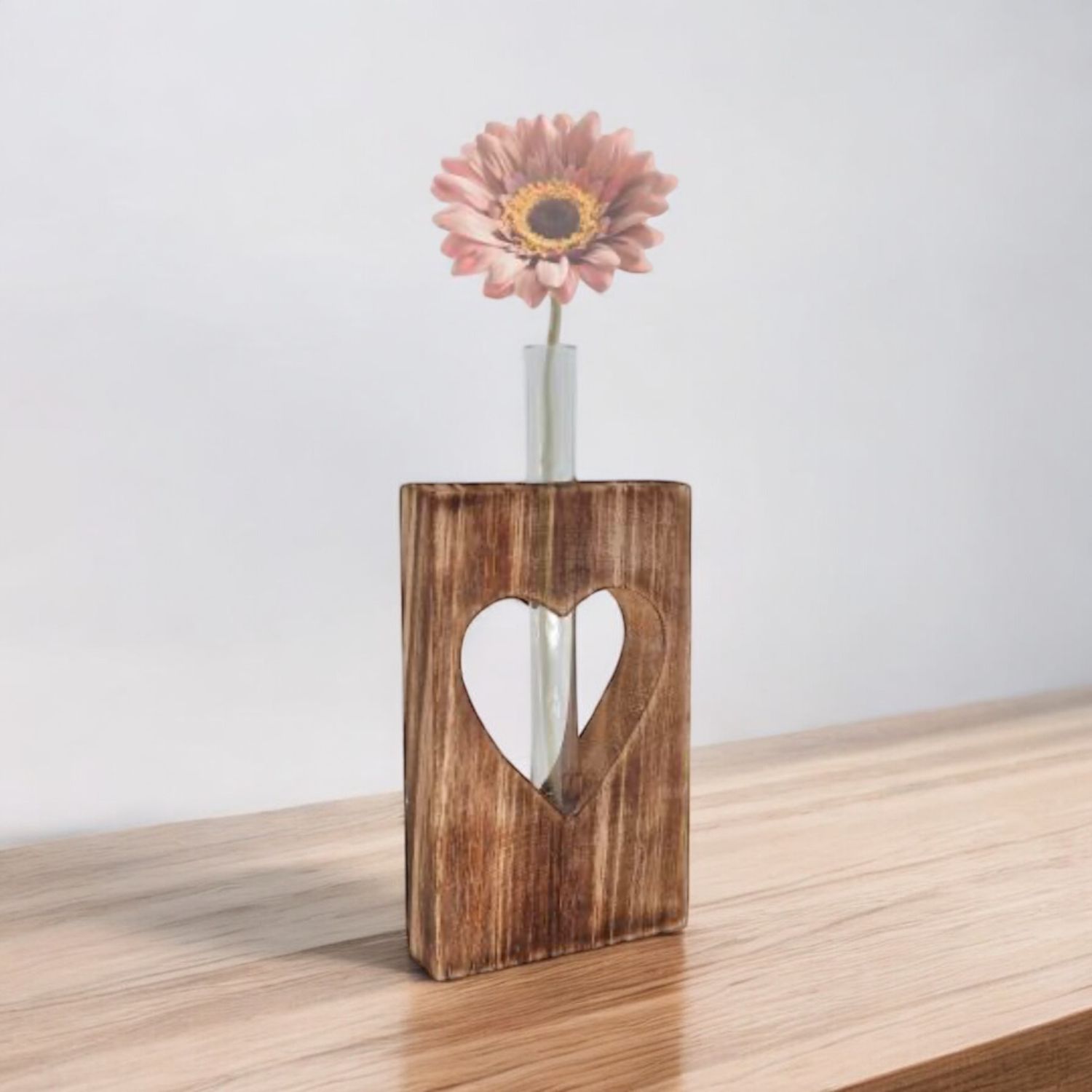 Blok hout met hart eruit gesneden en een glazen vaasje erin, troostcadeau