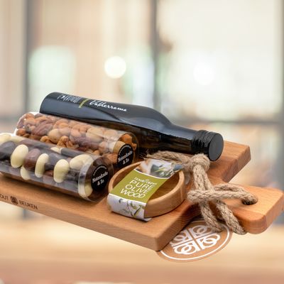 Houten serveerplank met schaaltje met Prosecco of olijfolie, noten en chocolade 