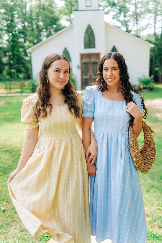 Close-up of pastel puff-sleeve dresses in yellow and blue with square necklines, perfect for spring and summer occasions.