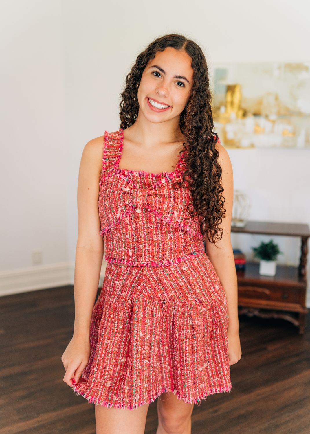 Model wearing pink multi tweed mini skirt with matching ruffle strap crop top, styled for a chic matching set look.