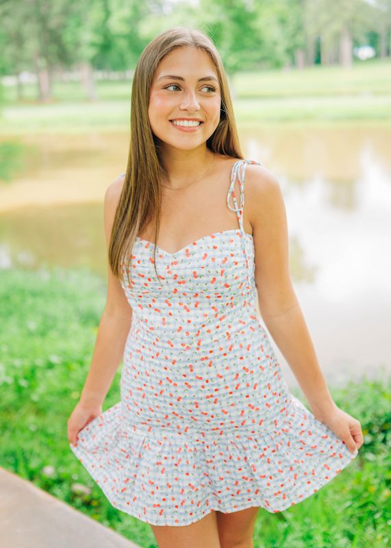 Close-up of romper’s bodice showing cherry print fabric and adjustable straps.