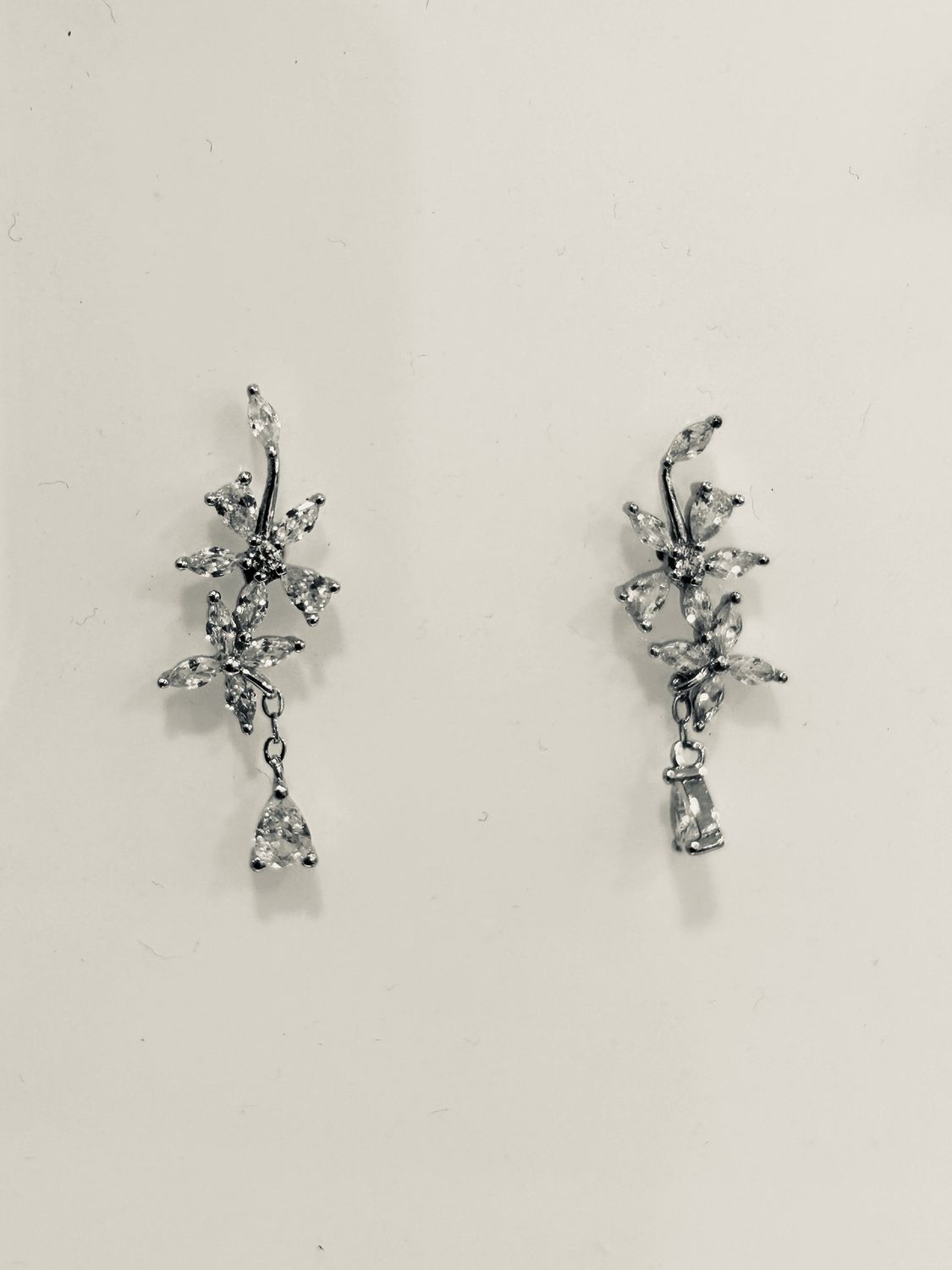 Oorbellen stekers met bloemvormige zirkonen en een hangend steentje