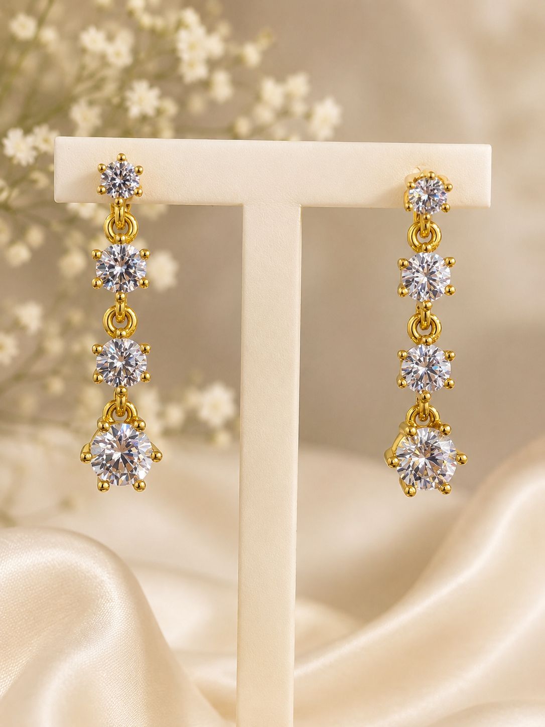 Elegante hangoorbellen met 4 fonkelende zirkonia's in oplopend formaat, verguld.