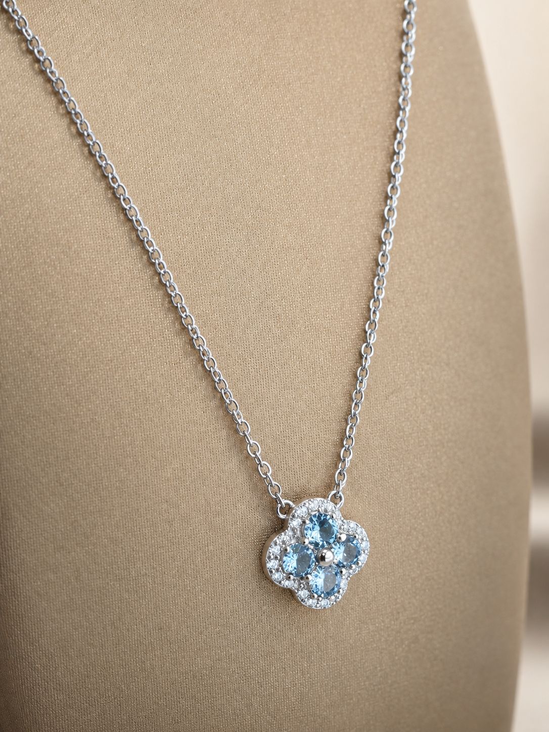 Zilveren ketting met bloemvormige hanger, afgewerkt met lichtblauwe en heldere zirkonia.