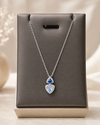 Zilveren ketting met dubbele driehoekige hanger, afgewerkt met donkerblauw, lichtblauw en heldere zirkonia.