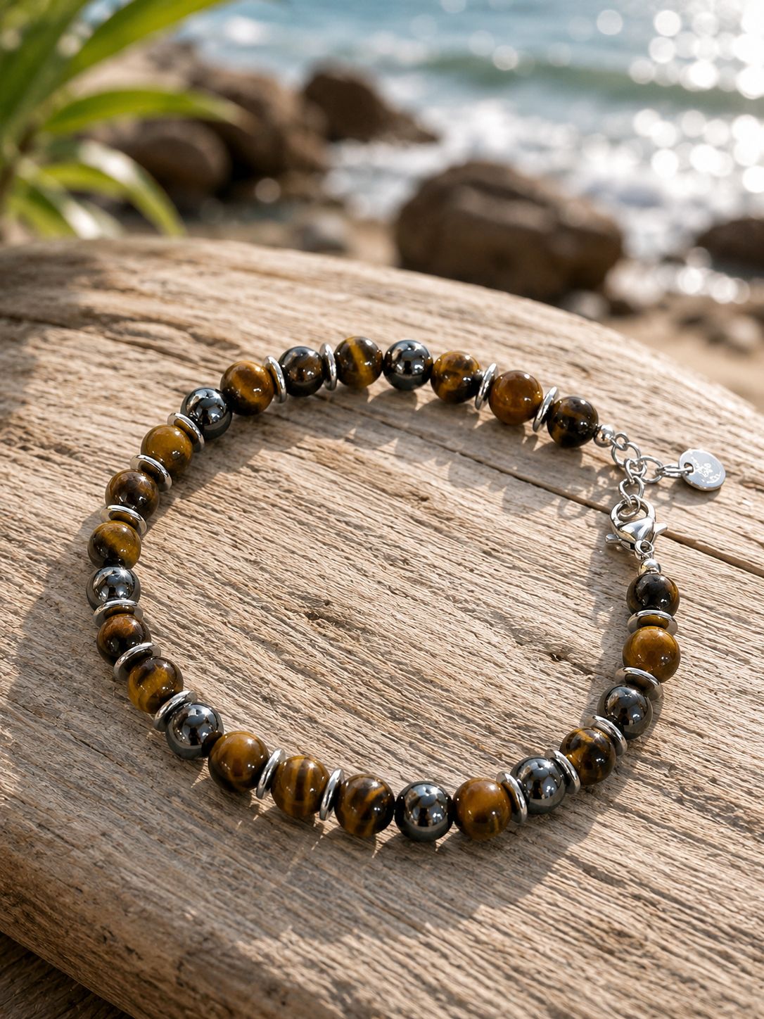 Natuursteenarmband op stevige staaldraad met karabijnsluiting. Gouden tijgeroog en hematiet