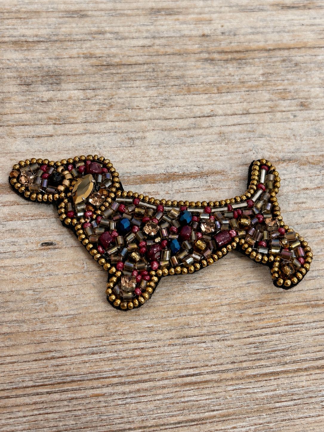 Broche hondje uit stof, bezet met kraaltjes