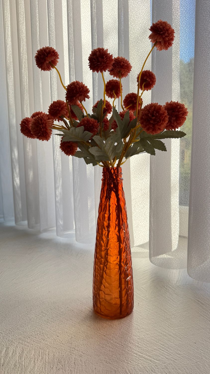 Glazen vaas oranje met kunstbloemen