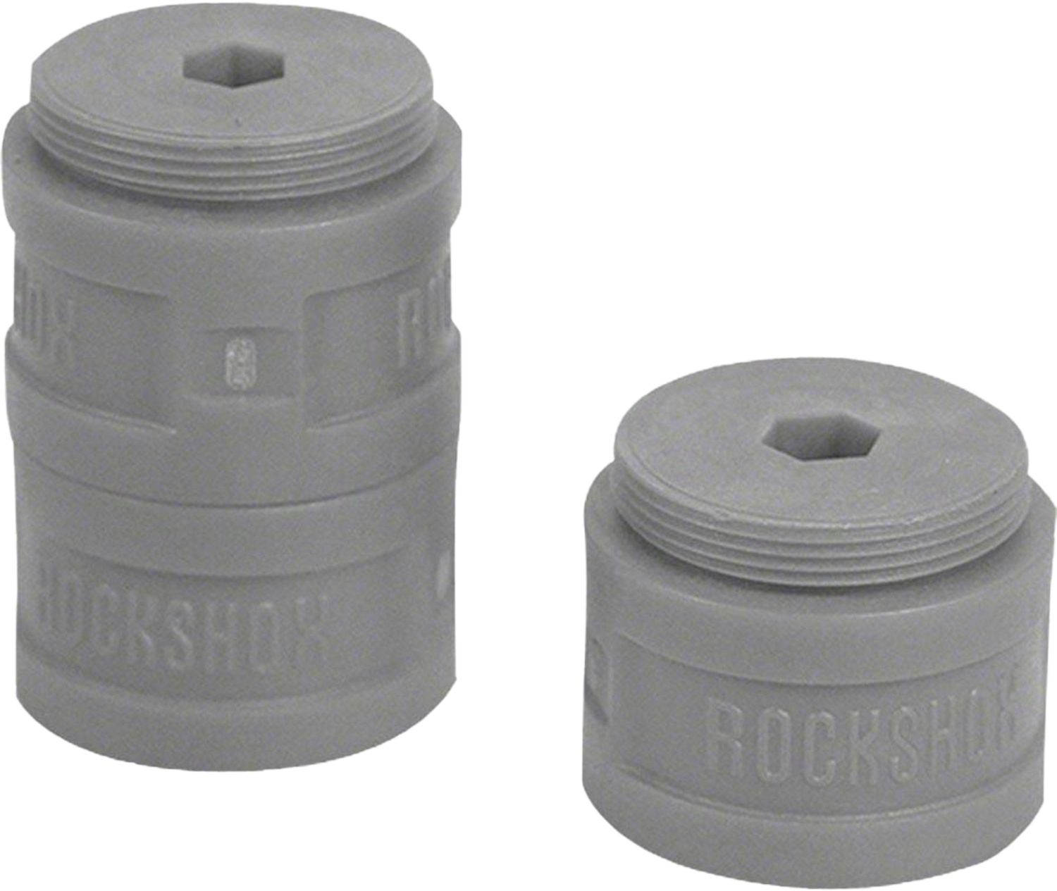 Three grey RockShox Bottomless Tokens volume reducer tokens for forks with 35mm stanchions