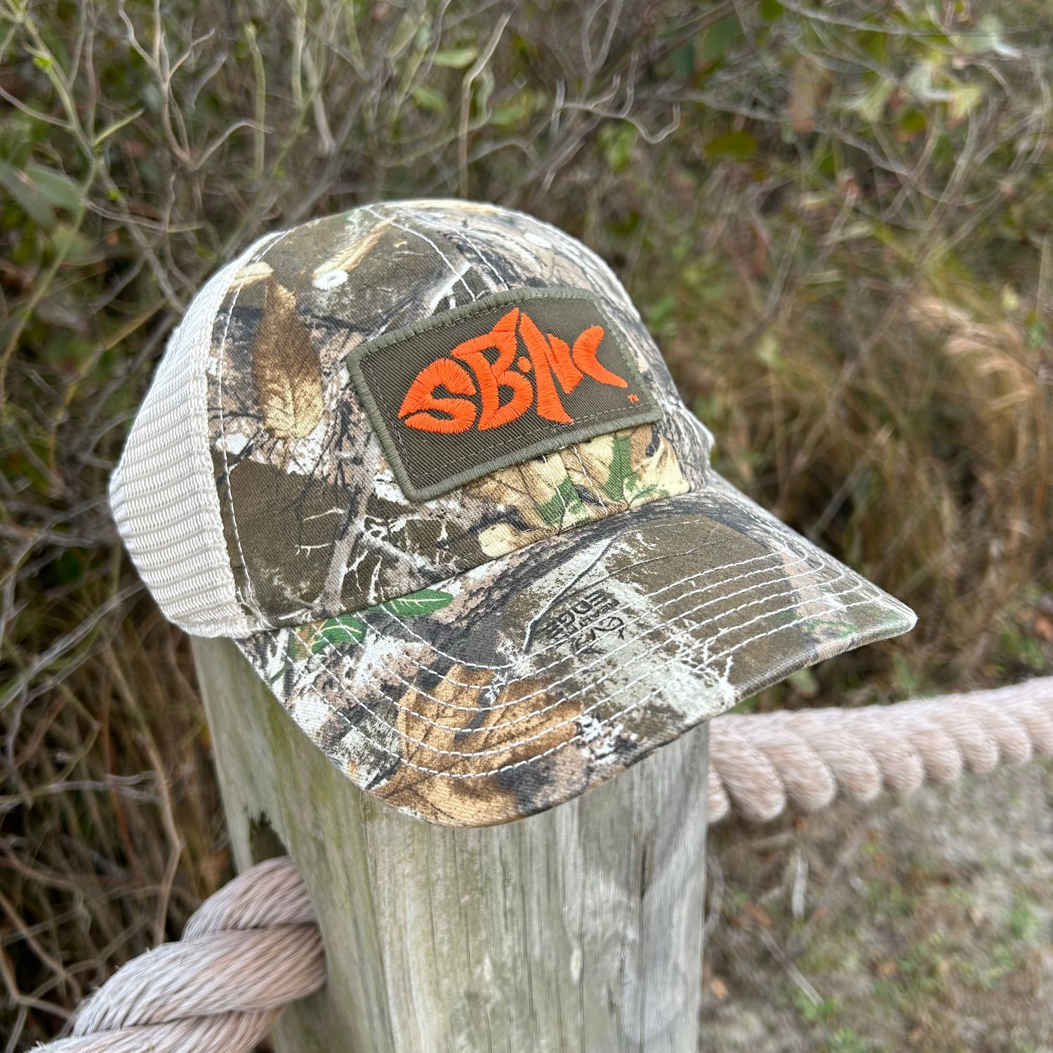 SBNC FISH BLAZE PATCH TRUCKER CAP (REALTREE EDGE)