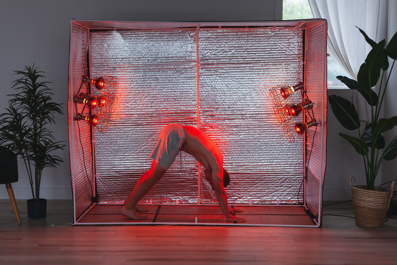 Downward dog yoga pose inside the Sauna Fix hot exercise sauna tent