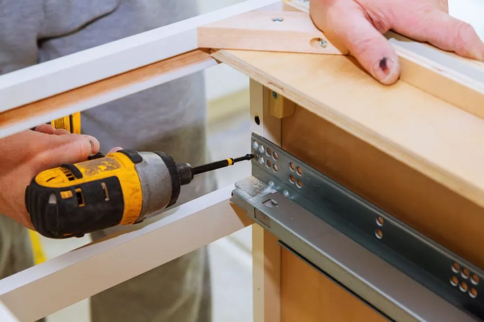 A person is using a drill to fix a piece of wood.