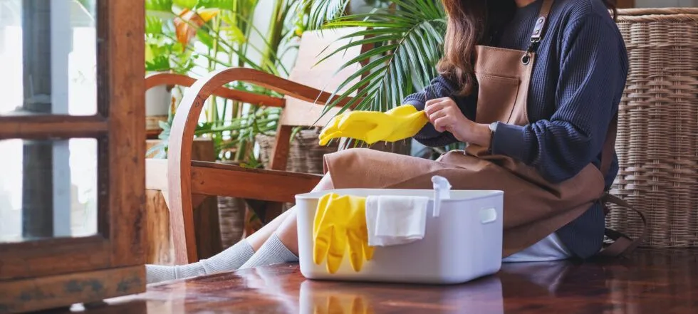 A woman is sitting on the floor cleaning the floor.