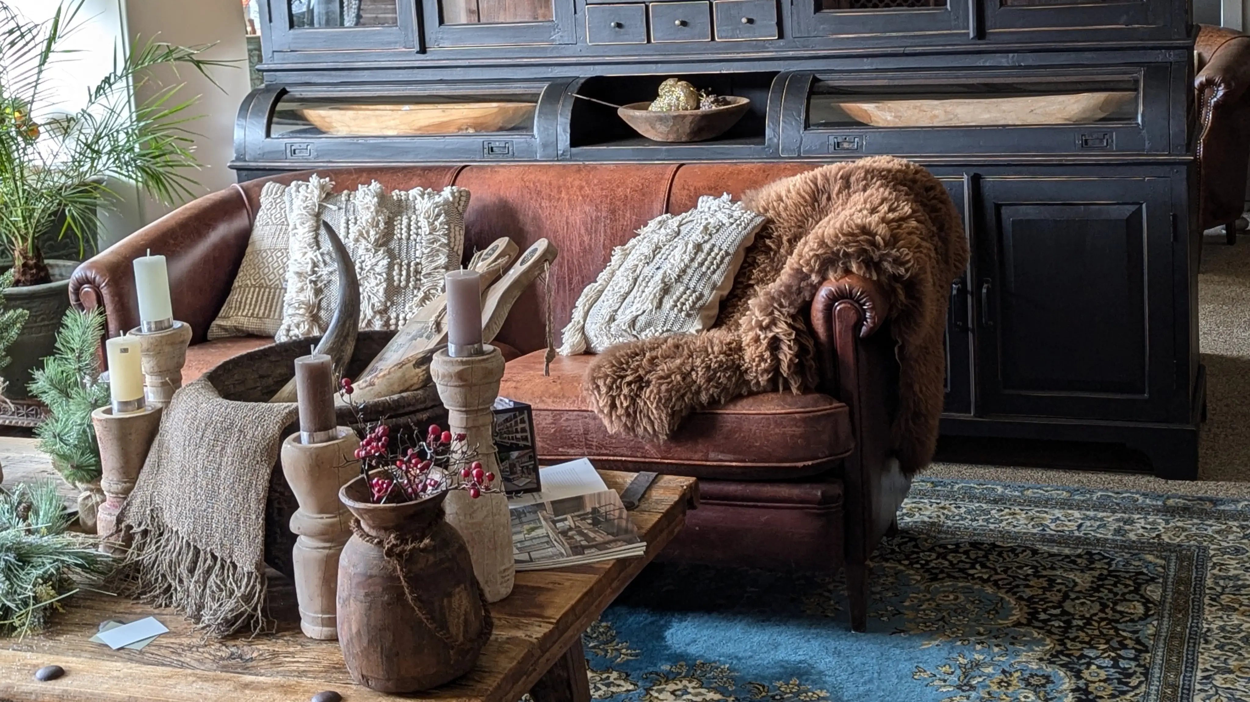Etalage van Woonwinkel ff iets anders in Goirle bij Tilburg. Met een schapen lederen bank, landelijke decoraties en een zwarte grutterskast.