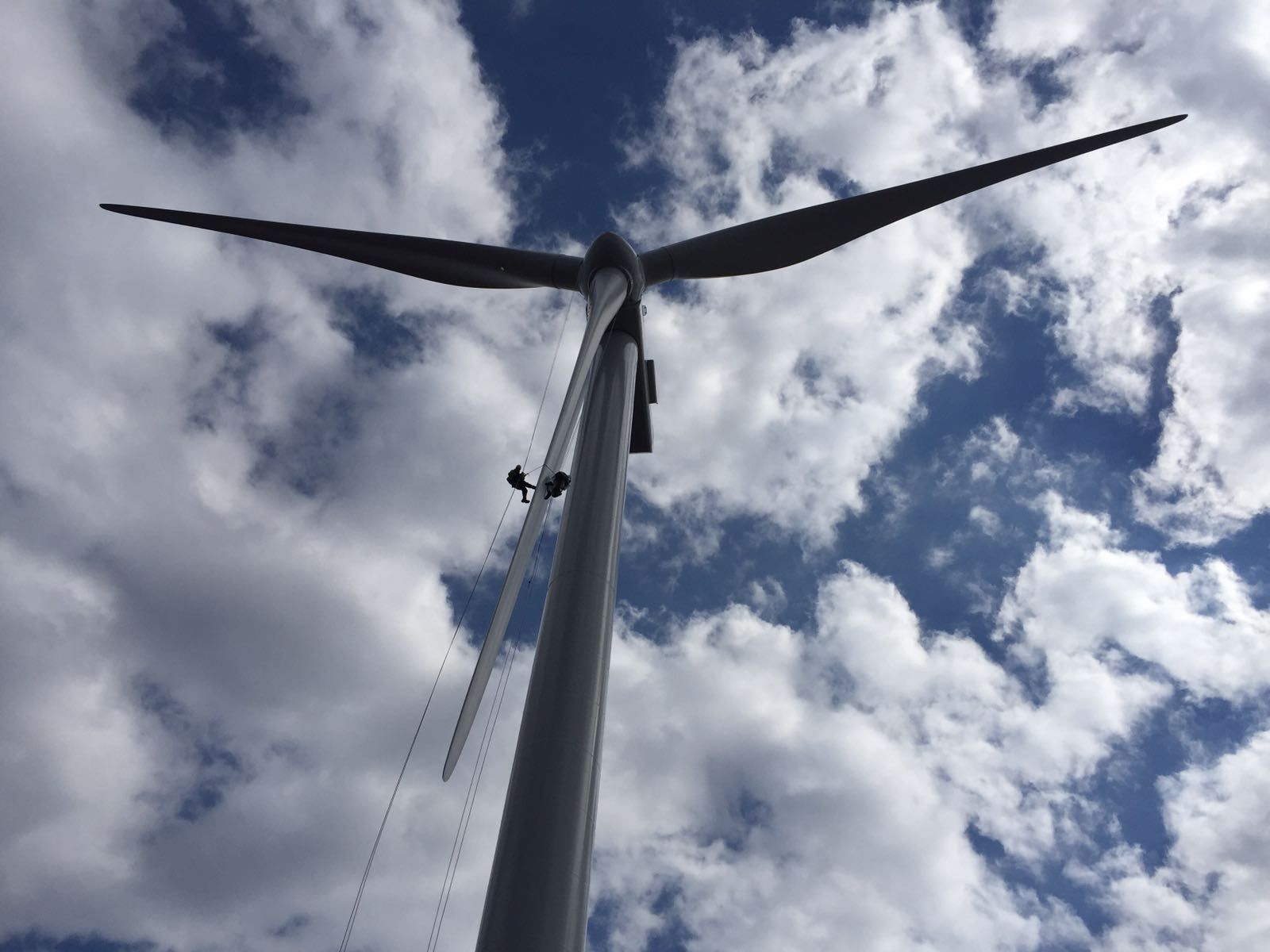 rope access techs rappelling down a high wind turbine blade