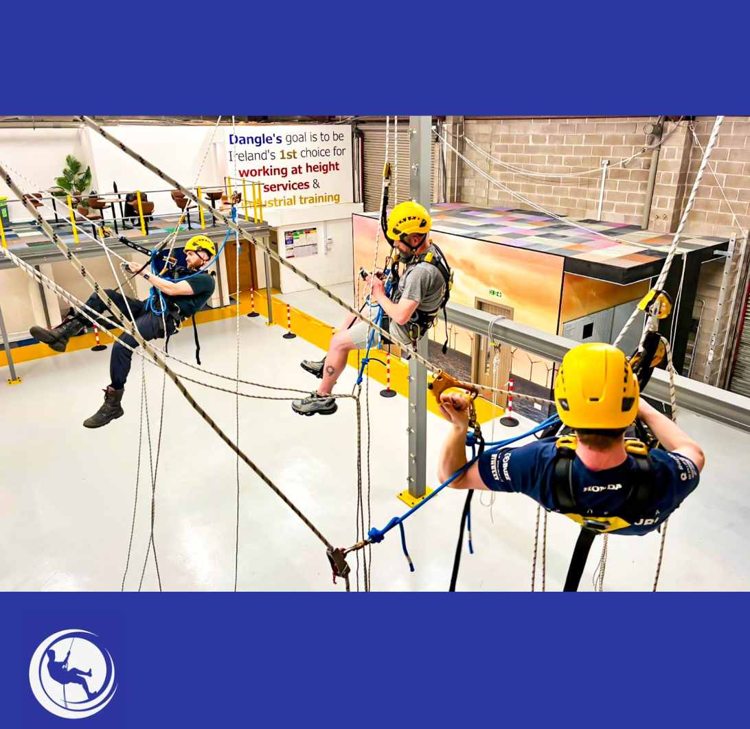 dangle academy training centre with students in full swing learning how to high abseil over grey floor and steelwork