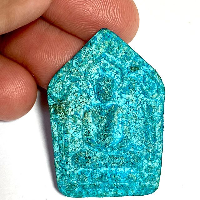 Front face of the amulet supported by the hand with a clear white background