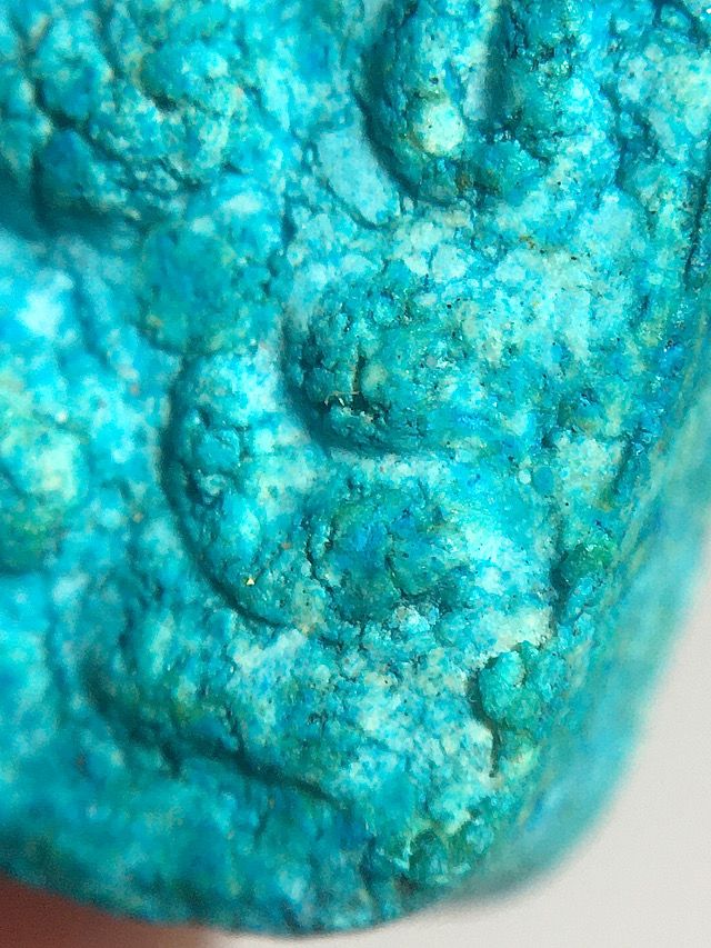 Macro close up image of the sacred powder admixture of the bottom right corner section of the front face of the amulet revealing the plethora of sacred ingredients and the natural aging properties of an authentic amulet of this great master